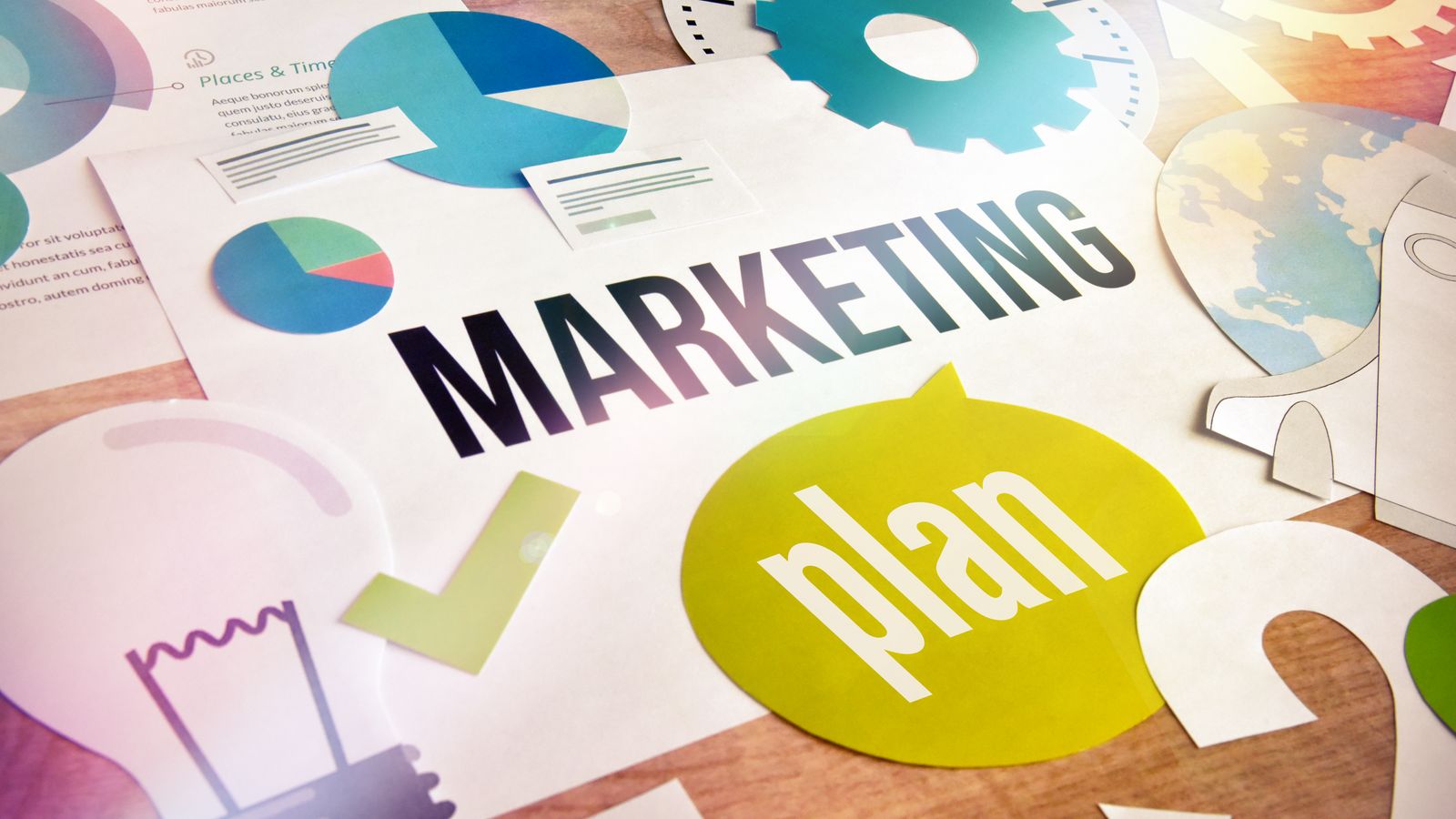 Plan de marketing recortado en papel con gráficas circulares, engranajes y la palabra Marketing plan